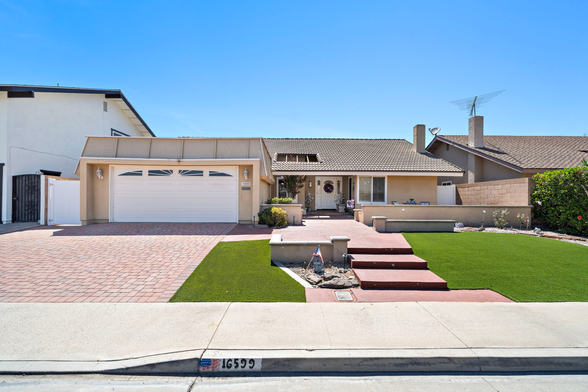 Single-story Fountain Valley home with brick paver driveway and manicured front yard