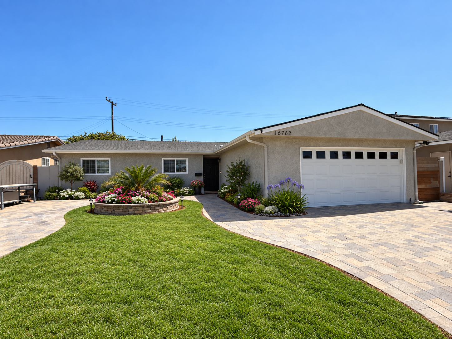 Exterior of 16762 Ross Ln in Huntington Beach with a landscaped front lawn, flower beds, and two-car garage