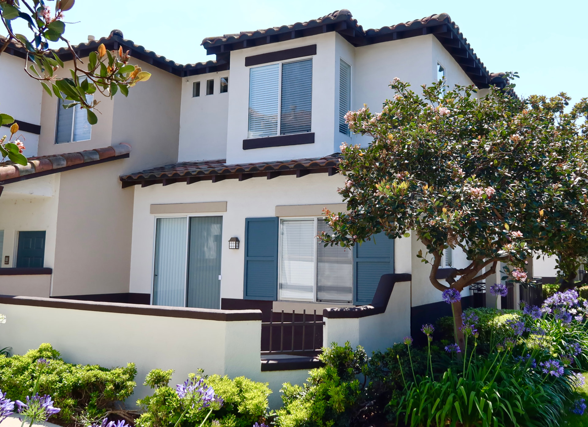 Two-story Tustin condominium with a private patio and flowering landscaping