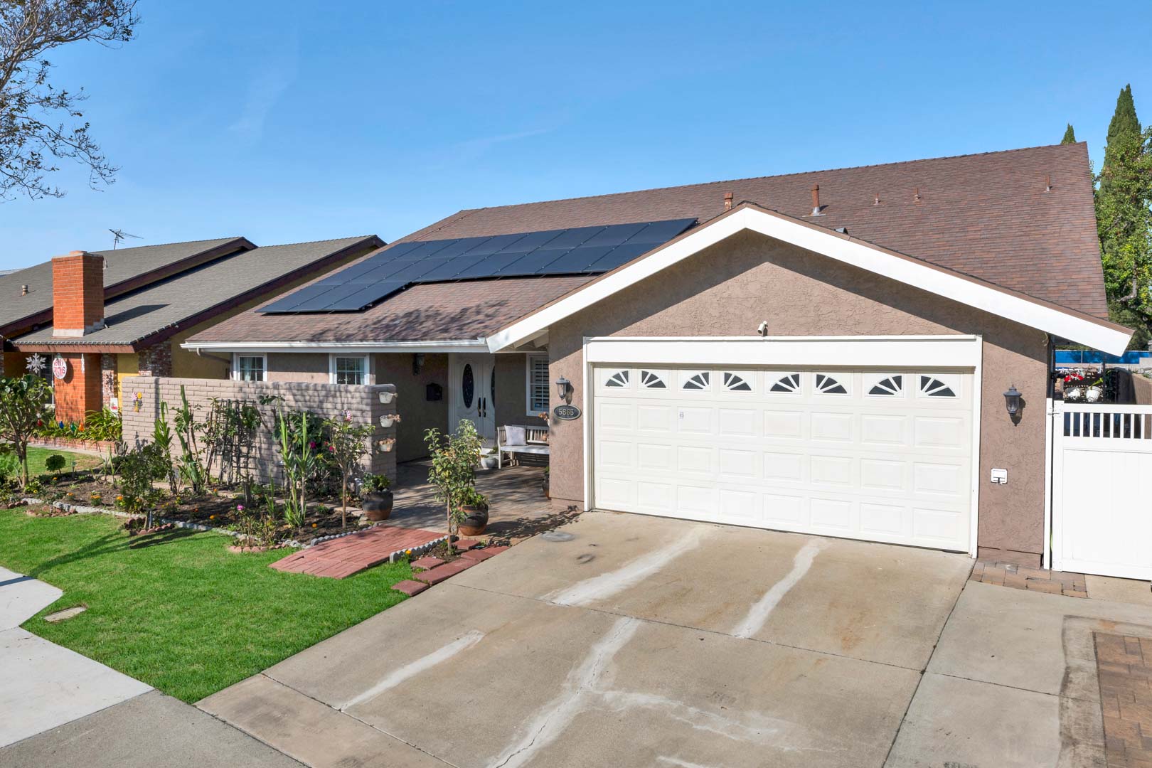 Cypress home with solar panels, two-car garage and flowering front garden