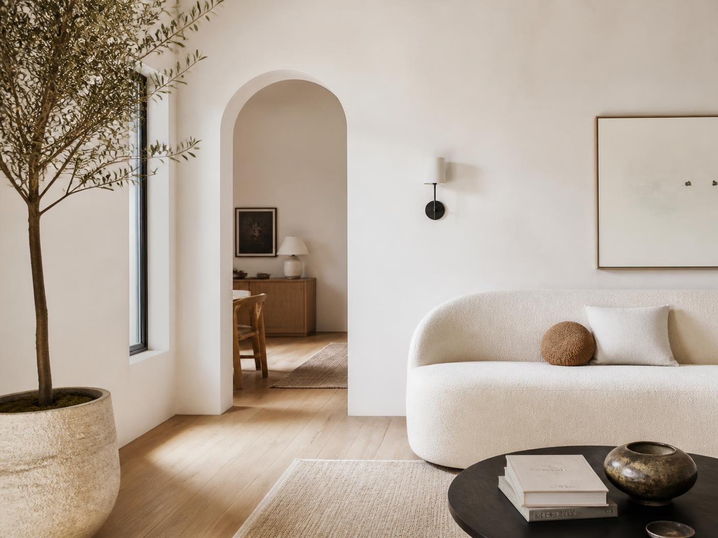 Bright minimalist Fountain Valley living room with arched doorway and oak floors