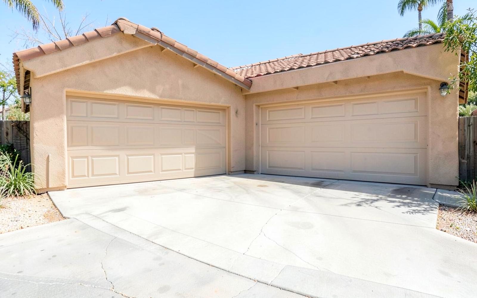 Attached two-car garage and clean concrete driveway of an Orange County home